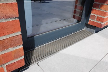This reveal area has also been fitted with a Stabile drainage channel. Here, the longitudinal bar grating cleverly contrasts with the brick façade and picks up on the mix of materials otherwise found throughout the building.  Photo: Richard Brink GmbH & Co. KG