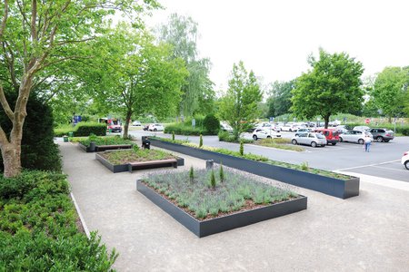 L’entreprise Richard Brink a fourni de grandes jardinières hautes fabriquées sur mesure et qui s’associent à des bancs aux couleurs assorties pour former un espace agréable où il fait bon s’attarder.