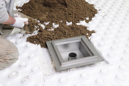 Once the DN 70 or DN 100 connection nozzle has been installed, expert installers use screed to fill the drain to the bottom edge of the flange. Four floor anchors lend the system stability.