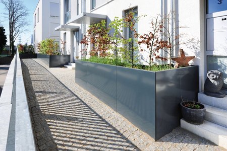 Made from aluminium and covered in an RAL 7016 plastic coating, the rectangular raised beds are 4mm thick and furnished with additional tie rods. Despite the large amounts of soil and greenery, the rods prevent the planters from buckling.