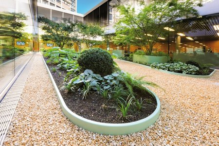 By contrast, the larger atrium makes an impression with green raised beds and curved lines.