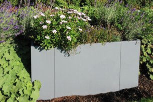 Modularer Pflanzkasten in grau im grünen Garten bepflanzt