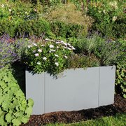 Modularer Pflanzkasten in grau im grünen Garten bepflanzt