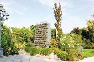 Freistehende Pflanzwand aus Metall mit Pflanzballen in einem grünen Garten