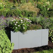 Modularer Pflanzkasten in grau im grünen Garten bepflanzt