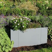 Modularer Pflanzkasten in grau im grünen Garten bepflanzt