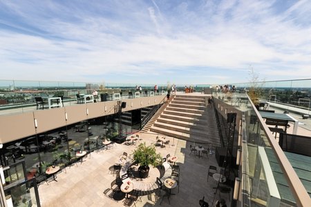 An internal courtyard is home to a café at the lower level on the roof, below the roof terrace. Steps take visitors from the courtyard up to the highest point of the Forum Groningen