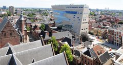 Der sich nach oben verjüngende Monolith ragt über den Dächern der Stadt aus dem sonst historischen Stadtkern hervor.