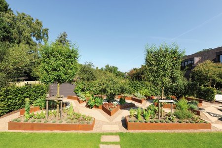 Deux jardinières hautes en forme d’étoile sont au cœur du potager entouré de versions en demi-étoiles qui encadrent le jardin de tous côtés.