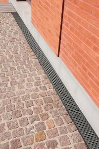 Le long des façades, des caniveaux en béton du spécialiste allemand des produits métalliques ont également été utilisés, mais coiffés, cette fois, de grilles en fonte « Prisma ».  Photo : Richard Brink GmbH & Co. KG