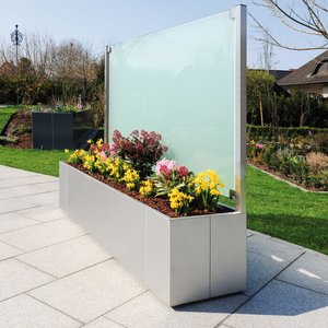 Metall Pflanzkasten aus Edelstahl mit satiniertem Glas als Rückwand auf der Terrasse im Garten