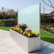 Metall Pflanzkasten aus Edelstahl mit satiniertem Glas als Rückwand auf der Terrasse im Garten