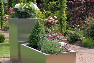 Pflanzkästen mit Pflanztrog aus Edelstahl mit blühenden Pflanzen auf der Terrasse im Garten