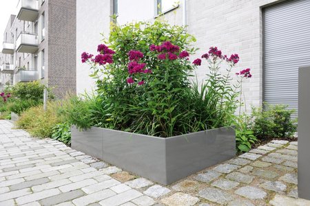 Au niveau des entrées, les jardinières hautes sur mesure en gris quartz s’intègrent agréablement à l’architecture.