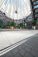 Auch das dunkle Pflaster bleibt getreu dem Motto „den Bestand durch Rekombination stärken“ erhalten, jedoch ersetzen fortan helle Granit- die ausgedienten Edelstahlplatten. Die neuen Rinnenstränge, deren Schlitzperforationen an das Muster des vorherigen Metallbelags angelehnt sind, leiten das anfallende Niederschlagswasser in einen darunter bestehenden 5 cm tiefen Hohlraum, der in die Kanalisation mündet.  Foto: Richard Brink GmbH & Co. KG