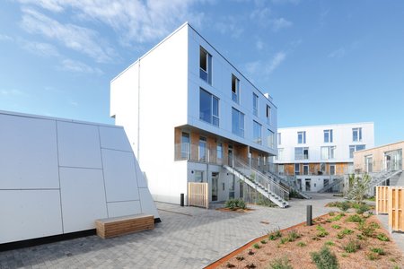 The residential buildings consist of prefabricated wood modules that were erected quickly and in an environmentally friendly way. Residents benefit from a modern, sustainably designed outdoor area with good connections to businesses and public transport.