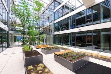 When designing the light-flooded atrium, the planners and the client MAGSI Wertimmobilien-Verwaltungs-GmbH wanted to give the space a natural touch by incorporating planted raised beds.