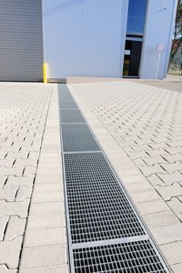 Les caniveaux ont été coiffés de grilles pour charges lourdes fabriquées sur mesure en tôle d’acier galvanisé.