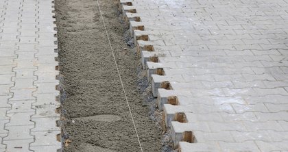 The paved surface and dewatering channels in the entrance to the company premises of Richard Brink GmbH & Co. KG areSecurely f exposed to heavy loads from goods vehicles. To ensure precipitation is drained away, Ferro Magna heavy-duty dewatering channels were installed in a strip foundation.