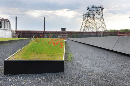 Die maßgefertigten Hochbeete mit einer mattschwarzen RAL-Beschichtung fügen sich optimal in die Komposition der verwendeten Materialien ein.