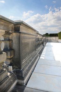 Les caniveaux à fente montés le long de la balustrade tantôt en saillie, tantôt en retrait créent une ligne toute en sobriété et un joint continu avec le dallage en grès.