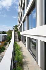 Die Vegetation ziert auch den gesamten Aufstieg, durch den jede Mieteinheit einen eigenen Zugang zum Außenbereich erhält, und begrünt das Gebäude vom Sockel bis zum Dach. In den Laibungsbereichen an den Türen und Fenstern der Glasfassade stellen dabei die Betonrinnen „Fortis“ zusammen mit den gusseisernen Designrosten „Zippa“ die Entwässerung sicher.    Fotos: Richard Brink GmbH & Co. KG