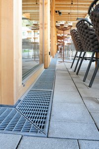 While guests enjoy a range of culinary delights in the outdoor area, the channels and gratings that line the façade continue the colour palette of the slab material and finish the front perfectly.