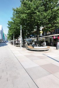 An inviting recreation area with organically arranged seating was created for passers-by underneath the existing row of 30-year-old lime trees. The seating includes elements of the concrete paving around it and features broad wooden benches.