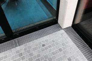 [Translate to Französisch:] Die Cubo Drainagerinne ist für Türschwellen mit anliegendem Pflastermaterial optimal geeignet