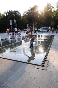 An warmen Sommertagen erfreuen sich Passanten und insbesondere Kinder am kühlen Nass des Wasserspiels.