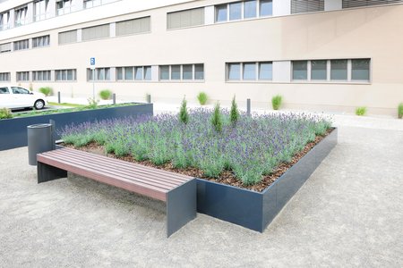 Coiffés d’assises en bois, les bancs ont opté pour des parois aux couleurs assorties à celles des systèmes de plantation pour une harmonie réussie.