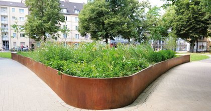 Die Anwohner des Neudorfer Markts in Duisburg kommen ab sofort in den Genuss einer neu gestalteten Grünanlage. Ein Hochbeet der Firma Richard Brink setzt dabei ganz wesentliche optische Akzente.