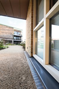 Gemeinsam mit den bunten Klinkerwänden und der großzügigen Begrünung ergeben sich fortan angenehme und kontrastreiche Farbspiele in der Wohnanlage, wobei auch die perforierten Roste ihren optischen Beitrag leisten.                 Fotos: Richard Brink GmbH & Co. KG 