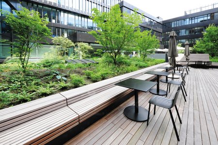 Des jardinières hautes Richard Brink organisent en plusieurs zones la cour utilisée aussi bien par la Volksbank Freiburg que par l’hôtel attenant.