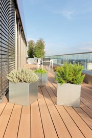 Quadratische Pflanzkästen aus Edelstahl auf einem modernen Balkon