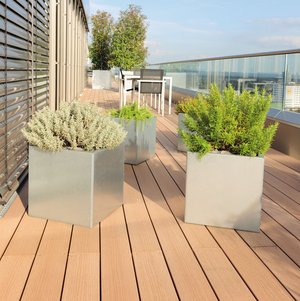 Quadratische Pflanzkästen aus Edelstahl auf einem modernen Balkon