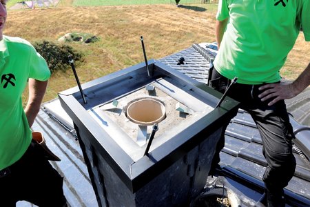 The shuttering frame for the chimney cap made of stainless steel sheet painted in black is positioned on the chimney.