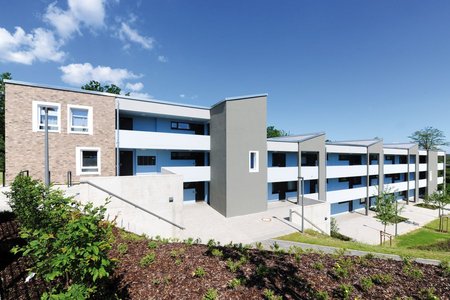 The individual floors of the block of flats are stacked along a slope. Paths and outdoor steps lead to the access points and terraces for the different levels.