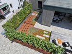 Übereck schließen großzügige Beetflächen mit rotem Substrat an die Terrassendielen an. Sie schaffen ausdrucksstarke Kontraste und fügen sich perfekt ins Gesamtwerk der neu geschaffenen Wohlfühloase ein.  Foto: Richard Brink GmbH & Co. KG