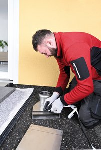 Am Regenfallrohr wird anfallender Niederschlag über Adapter aufgenommen und anschließend in ein Flachkanalsystem geleitet. Zur Verbindung von Adapter und Flachkanal wird zunächst ein beiliegendes EPDM-Band umlaufend am Adapter angebracht.  Foto: Richard Brink GmbH & Co. KG