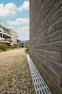 Gemeinsam mit den bunten Klinkerwänden und der großzügigen Begrünung ergeben sich fortan angenehme und kontrastreiche Farbspiele in der Wohnanlage, wobei auch die perforierten Roste ihren optischen Beitrag leisten.                 Fotos: Richard Brink GmbH & Co. KG 