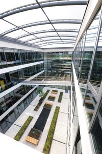 A bright atrium inside the building gives employees a place to relax and recharge. A lightweight membrane roof structure lets in plenty of daylight.