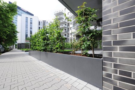 Thanks to the dark grey plastic coating, the raised beds fit in aesthetically with the brick façade and paving.