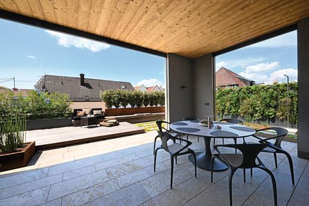 Als Entree wurde ein überdachter Bereich gebaut, der L-förmig von der Terrasse umschlossen wird. Er bietet den Bewohnern die Möglichkeit, auch bei schlechtem Wetter nicht auf den Aufenthalt an der frischen Luft verzichten zu müssen.  Foto: Richard Brink GmbH & Co. KG