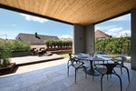 Als Entree wurde ein überdachter Bereich gebaut, der L-förmig von der Terrasse umschlossen wird. Er bietet den Bewohnern die Möglichkeit, auch bei schlechtem Wetter nicht auf den Aufenthalt an der frischen Luft verzichten zu müssen.  Foto: Richard Brink GmbH & Co. KG