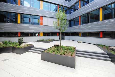 The inner courtyard, which was largely covered in grass, greenery and a pond, now fits in nicely with the tidy structure of the façade. A total of five raised beds divide the space into two sections on different levels.