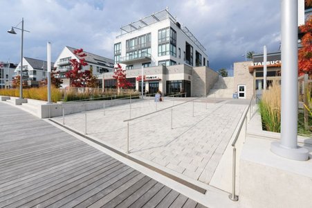 The promenade invites the district's residents and visitors to enjoy a stroll and pop into the various shops and restaurants, where they can relax and do a little shopping. Dewatering channels keep the wide ramps that lead from the promenade to the jetties dry.